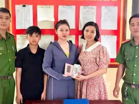 Cháu Nguyễn Anh Vũ và mẹ trao trả lại tài sản cho người đánh rơi tại trụ sở Công an xã Liên Hoa.