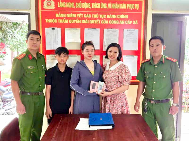Cháu Nguyễn Anh Vũ và mẹ trao trả lại tài sản cho người đánh rơi tại trụ sở Công an xã Liên Hoa.